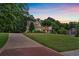 Long driveway leads up to a two-story home, surrounded by lush greenery at 1220 Waterfall Nw Ln, Acworth, GA 30101