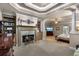 Luxurious main bedroom with tray ceilings, a fireplace, built-in shelving, and a cozy seating area at 1220 Waterfall Nw Ln, Acworth, GA 30101
