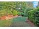 Beautifully manicured putting green area surrounded by lush landscaping and trees at 1220 Waterfall Nw Ln, Acworth, GA 30101