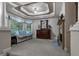 Sitting Room showcasing decorative tray ceiling, neutral colors, fireplace, and large window with backyard view at 1220 Waterfall Nw Ln, Acworth, GA 30101