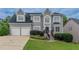 Charming two-story home with a well-manicured lawn, two-car garage, and a classic gray stucco facade at 1706 Brandon Lee Sw Way, Marietta, GA 30008