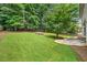 Large, landscaped backyard with mature trees and stone patio at 2010 Pearwood Path, Roswell, GA 30076