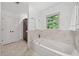 Soaking tub in bright bathroom with marble accents and a window view at 2010 Pearwood Path, Roswell, GA 30076
