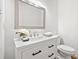 Bright bathroom featuring white vanity with granite countertop, decorative mirror, and commode at 2010 Pearwood Path, Roswell, GA 30076