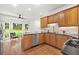 Well-lit kitchen features wooden cabinets, a stainless steel dishwasher, and a view to the backyard at 2010 Pearwood Path, Roswell, GA 30076