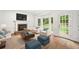 Cozy living room with hardwood floors, a fireplace, and large windows offering backyard views at 2010 Pearwood Path, Roswell, GA 30076