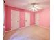 Bright pink bedroom features a ceiling fan and three closets at 2985 Heather Stone Way, Lawrenceville, GA 30043