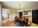 An inviting dining room featuring wood floors, a classic table set, and adjacent living spaces at 2985 Heather Stone Way, Lawrenceville, GA 30043