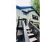 View of a two-story home's entrance, with black shutters, a black door, and stairs with black railing at 2985 Heather Stone Way, Lawrenceville, GA 30043