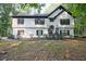 Two-story home featuring mature trees, a chimney, black shutters, and a well-maintained front yard at 2985 Heather Stone Way, Lawrenceville, GA 30043