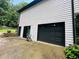 Attached garage with modern door, next to sliding doors and a stone retainer wall at 2985 Heather Stone Way, Lawrenceville, GA 30043