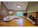 Bright living room with hardwood flooring, white sofa, and brick fireplace with a ceiling fan at 2985 Heather Stone Way, Lawrenceville, GA 30043