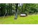 Playground with swing set, slide, and seating area in a grassy backyard surrounded by trees at 2985 Heather Stone Way, Lawrenceville, GA 30043