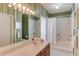 Bathroom features a white vanity, tub, shower, and decorative mirror with Hollywood-style lighting at 3585 Berkeley Park Ct, Duluth, GA 30096