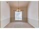 Elegant dining room featuring chair rail molding, neutral carpeting, and a chandelier for a sophisticated ambiance at 3585 Berkeley Park Ct, Duluth, GA 30096