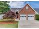 Charming brick home featuring a two-car garage, well-manicured lawn, and inviting red front door at 3585 Berkeley Park Ct, Duluth, GA 30096