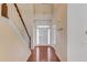 Bright foyer featuring hardwood floors, a staircase, and a glimpse of the white front door at 3585 Berkeley Park Ct, Duluth, GA 30096