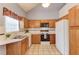 Functional kitchen featuring wood cabinets, white appliances, and a window for natural light at 3585 Berkeley Park Ct, Duluth, GA 30096