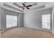 Comfortable bedroom with large windows, a ceiling fan, and neutral carpet at 3585 Berkeley Park Ct, Duluth, GA 30096