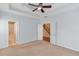 Spacious main bedroom boasts a tray ceiling, ceiling fan, and multiple entry points at 3585 Berkeley Park Ct, Duluth, GA 30096