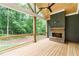 Cozy back porch with a fireplace and ceiling fan overlooking a private wooded backyard at 7080 Driskell Cir, Cumming, GA 30041