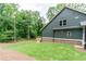 A freshly mowed lawn surrounds a green home exterior and a small wooden deck at 7080 Driskell Cir, Cumming, GA 30041