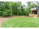 Lush green backyard featuring an outdoor porch and beautiful views of the surrounding woodland at 7080 Driskell Cir, Cumming, GA 30041