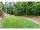 Lush backyard features a level lawn, wooded backdrop, and beautiful landscaping at 7080 Driskell Cir, Cumming, GA 30041