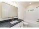 Bathroom featuring a shower and tub combination and white vanity with black countertop and gold hardware at 7080 Driskell Cir, Cumming, GA 30041