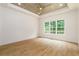 Spacious bedroom featuring wood ceiling, recessed lights, a large window with nature views, and hardwood flooring at 7080 Driskell Cir, Cumming, GA 30041
