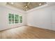 Bright, large bedroom with a modern ceiling fan, hardwood floors, and large picture window at 7080 Driskell Cir, Cumming, GA 30041