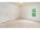 Bedroom with white walls, large window with natural light and double closets with gold hardware at 7080 Driskell Cir, Cumming, GA 30041