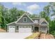 Charming home showcasing a welcoming three-car garage and a beautifully landscaped front yard at 7080 Driskell Cir, Cumming, GA 30041