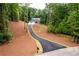 Traditional home with a well-manicured lawn and a winding driveway through a wooded lot at 7080 Driskell Cir, Cumming, GA 30041