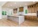 Bright kitchen with large marble island, wood cabinets, and backyard view at 7080 Driskell Cir, Cumming, GA 30041