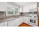 Bright kitchen featuring white cabinets, updated appliances, and a stylish backsplash at 1891 8Th St, Atlanta, GA 30341