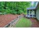 Spacious backyard with a retaining wall, lush lawn, and a screened-in porch, ideal for relaxing at 3286 Crawford Cir, Marietta, GA 30066