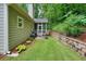 Landscaped backyard featuring a patio, retaining wall, lush grass, and surrounding trees at 3286 Crawford Cir, Marietta, GA 30066