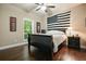 Comfortable bedroom features a dark wood floor, ceiling fan, window and a black and white American flag at 3286 Crawford Cir, Marietta, GA 30066