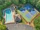 Aerial view of the community pool, tennis courts, and clubhouse surrounded by lush trees at 2900 Sutton Pl, Conyers, GA 30013
