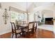 Dining room with a wooden table and seating for six overlooking green backyard at 2900 Sutton Pl, Conyers, GA 30013