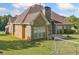 View of the back of the home, showing the brick facade, covered patio, and manicured lawn at 2900 Sutton Pl, Conyers, GA 30013