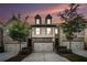 Beautiful townhome with a two-car garage, manicured landscaping, and a stone facade at dusk at 2909 Emme Ct, Conyers, GA 30094