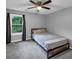 Neutral bedroom featuring a window, ceiling fan, and twin bed with decorative grey bedding at 3190 Water Brook Sw Dr, Conyers, GA 30094