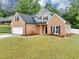 Well-maintained two-story brick home featuring an attached two-car garage and side yard at 3190 Water Brook Sw Dr, Conyers, GA 30094