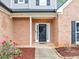 Close up of home's entry featuring a black door, mulch flower beds, and manicured lawn at 3190 Water Brook Sw Dr, Conyers, GA 30094