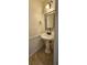 Stylish powder room with a pedestal sink, decorative mirror, and tile flooring at 4965 N Bridges Dr, Alpharetta, GA 30022
