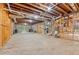 Unfinished basement with exposed beams, concrete floor, and walk-out doors to the backyard at 827 Holly Rdg, Canton, GA 30115