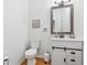 Half-bathroom with modern sink, vanity, white toilet, wooden floors, and painted walls at 827 Holly Rdg, Canton, GA 30115