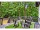 Beautiful deck perfect for relaxing outdoors with rocking chairs, artificial grass, and wooded scenery at 827 Holly Rdg, Canton, GA 30115